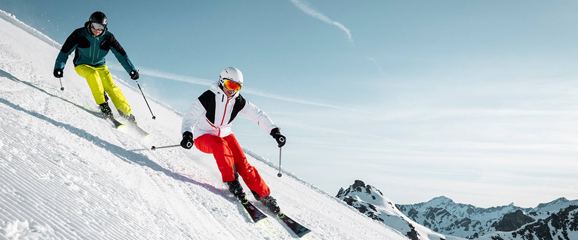 Zwei Skifahrer carven die Piste