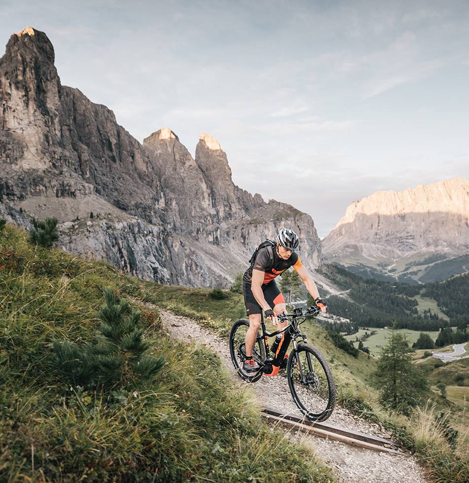 Ein Mann ist gerade auf seinem E-Mountainbike auf den Weg ins Tal.
