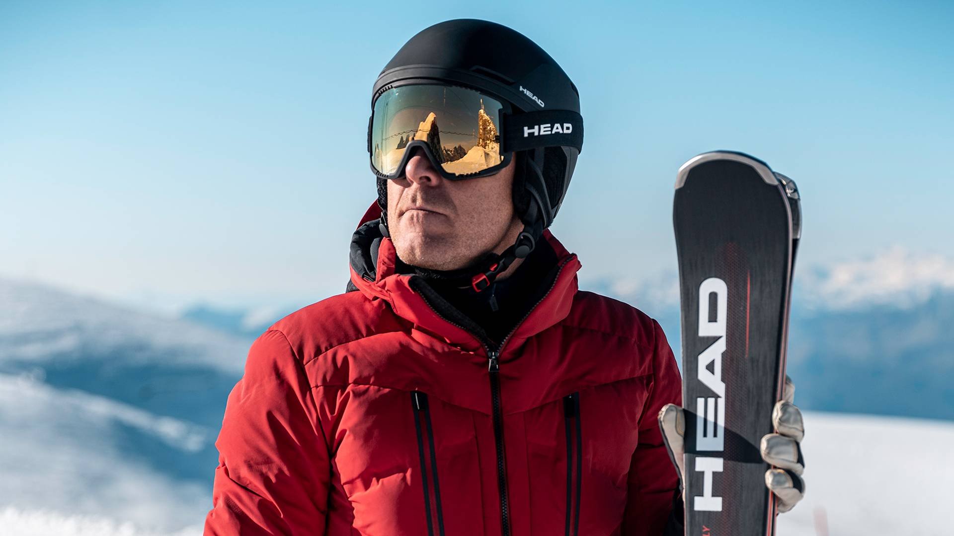 Een skiër houdt zijn ski in de hand.