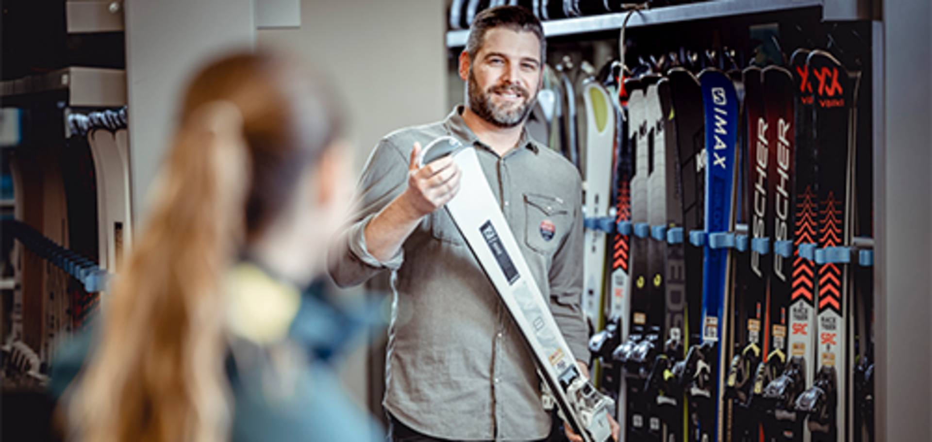 An employee presents the various rental skis.