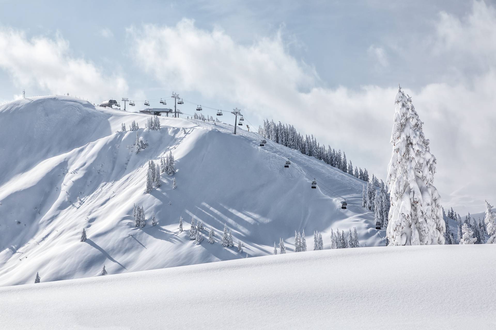 Snow-covered mountain landscape, you can see the chairlift's mountain station