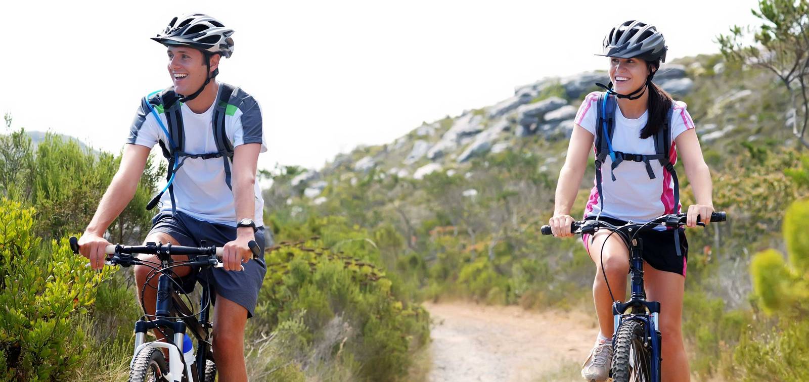 Zwei Mountainbiker sind sportlich auf einem Trail unterwegs.