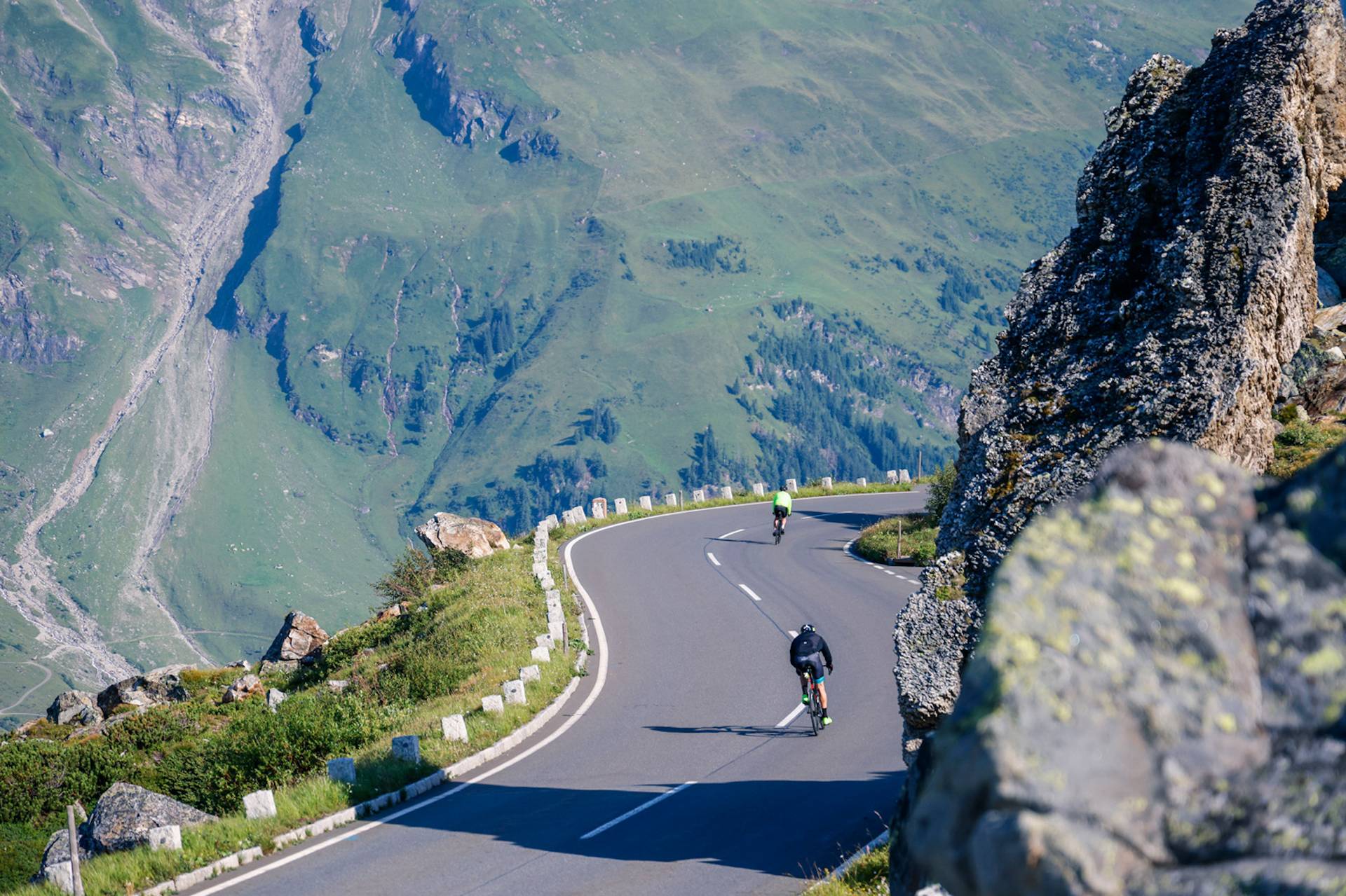 Radfahrer fahren entlang einer Bergstraße.