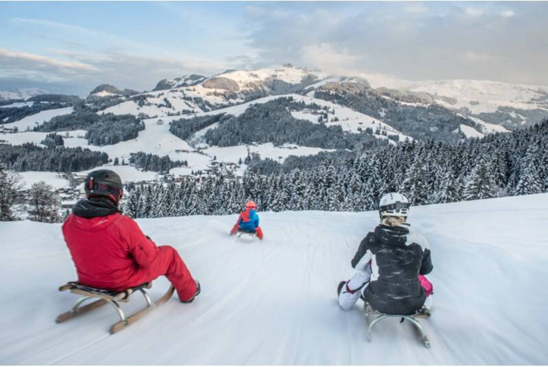 A family sledging in the evening.