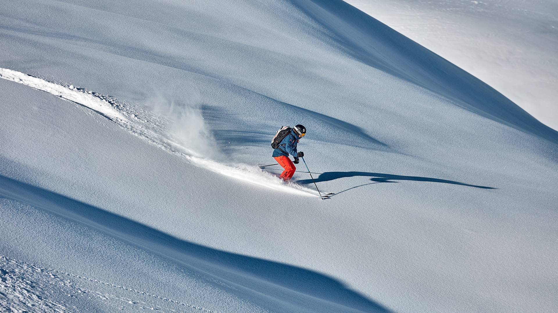 A man skis down a slope at high speed.