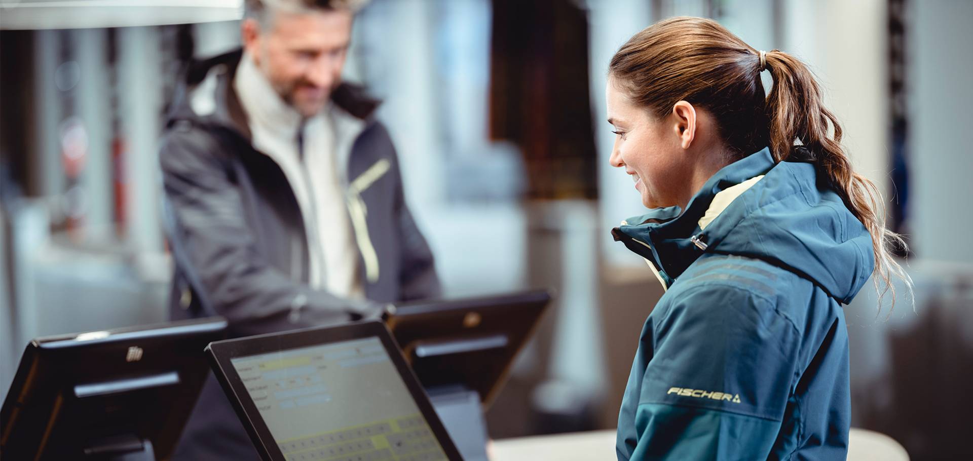 Een klant voert de check-in uit op een van de twee daarvoor bestemde laptops in een winkel.