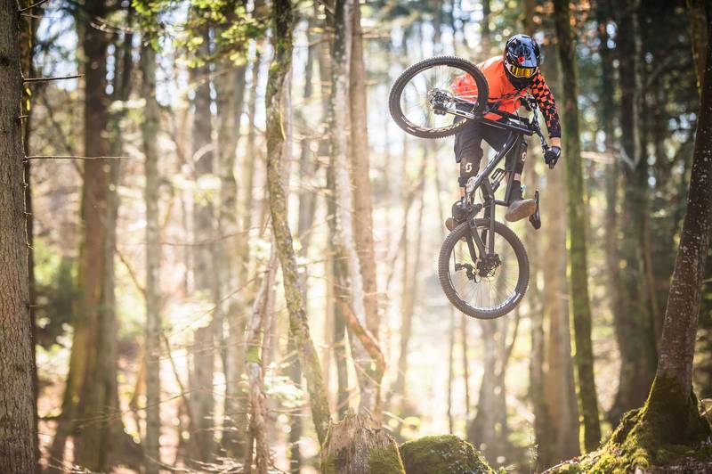 Biker führt einen Trick mit einem Downhill Bike aus.