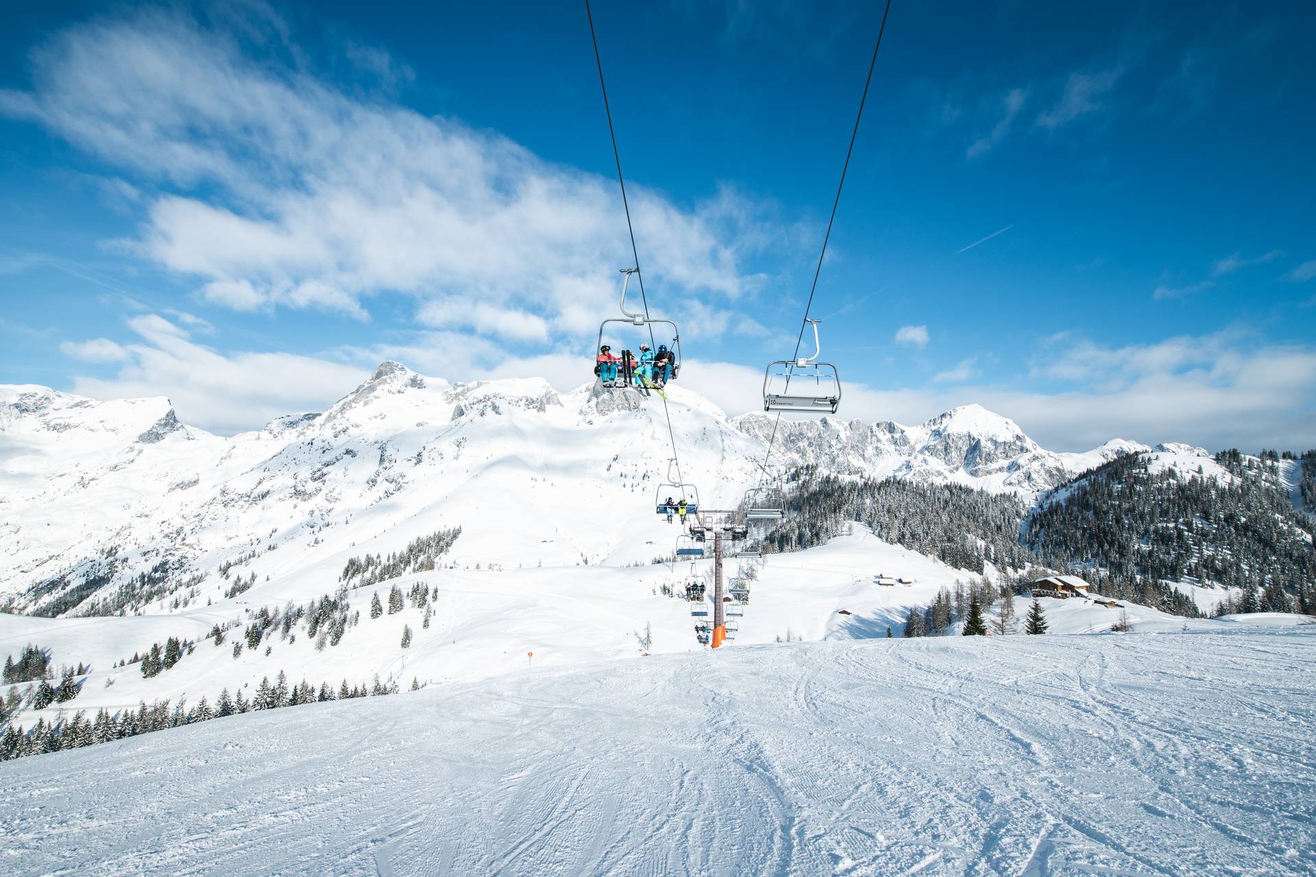View of the chairlift in Werfenweng, three people sitting in the lift
