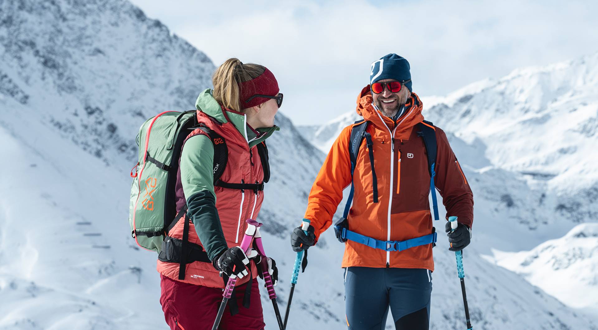 A photo of a ski touring couple with happy expressions.