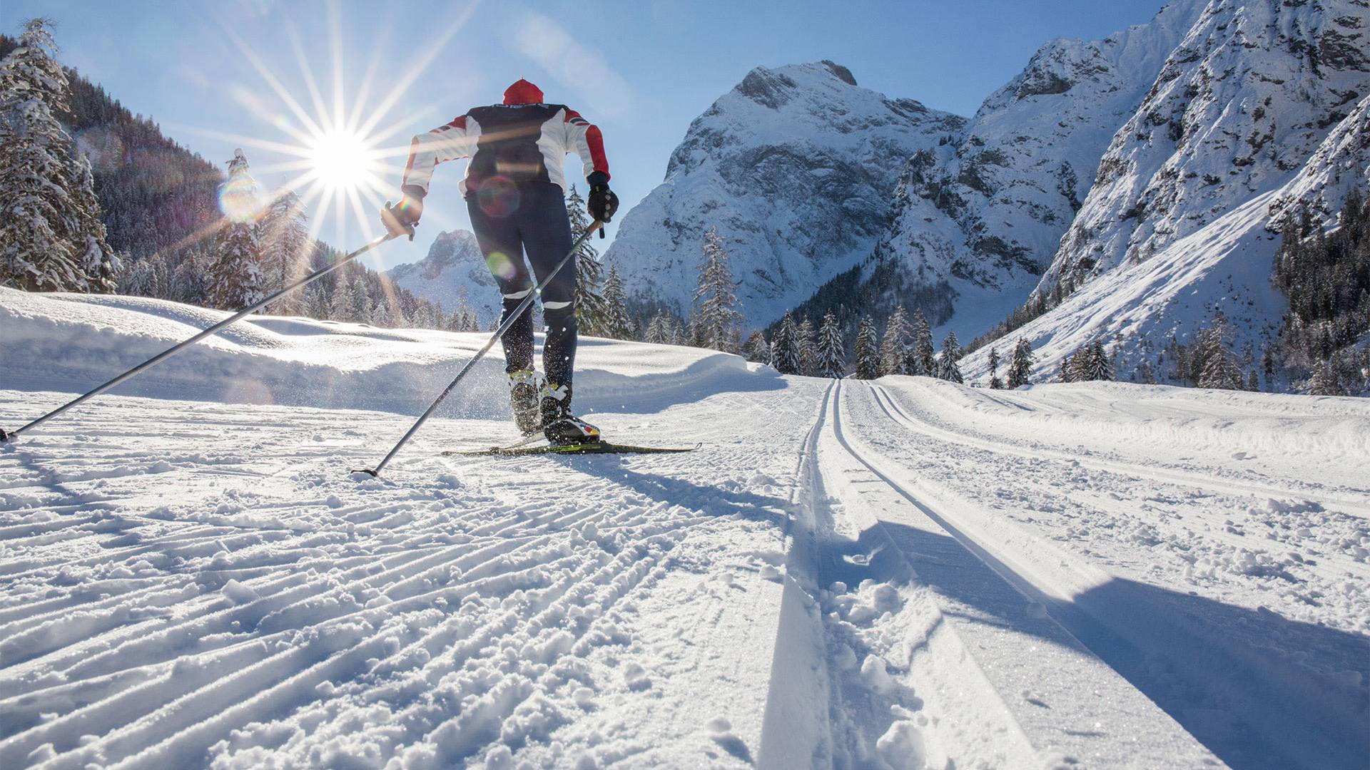 A cross-country skier is skiing at full speed, clearly enjoying the weather.