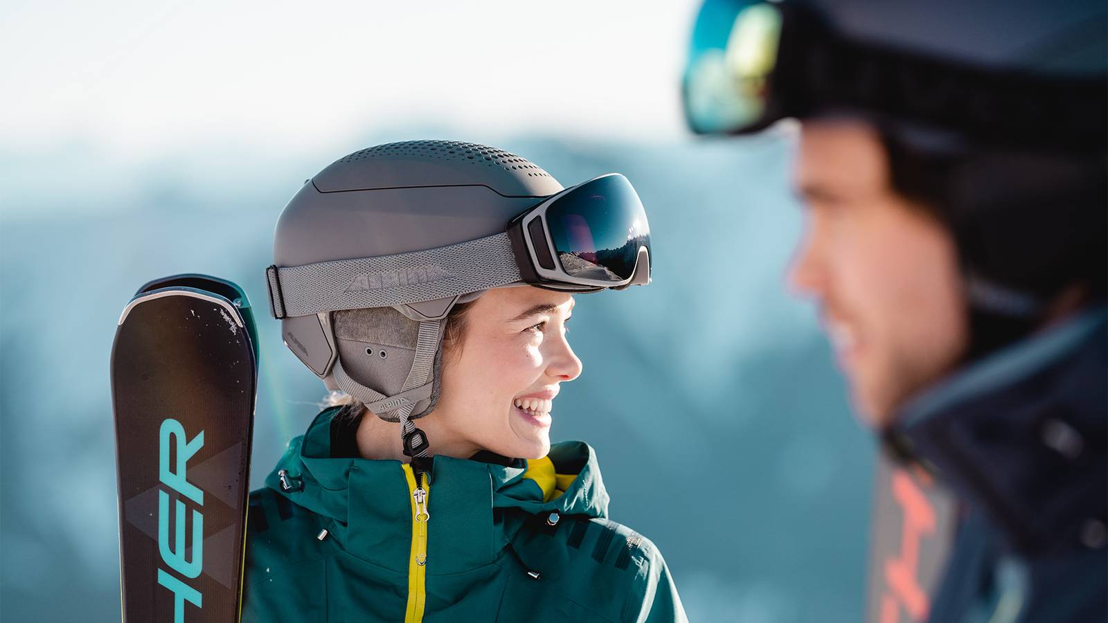 Zwei Skifahrer blickend auf ein winterliches Bergpanorama