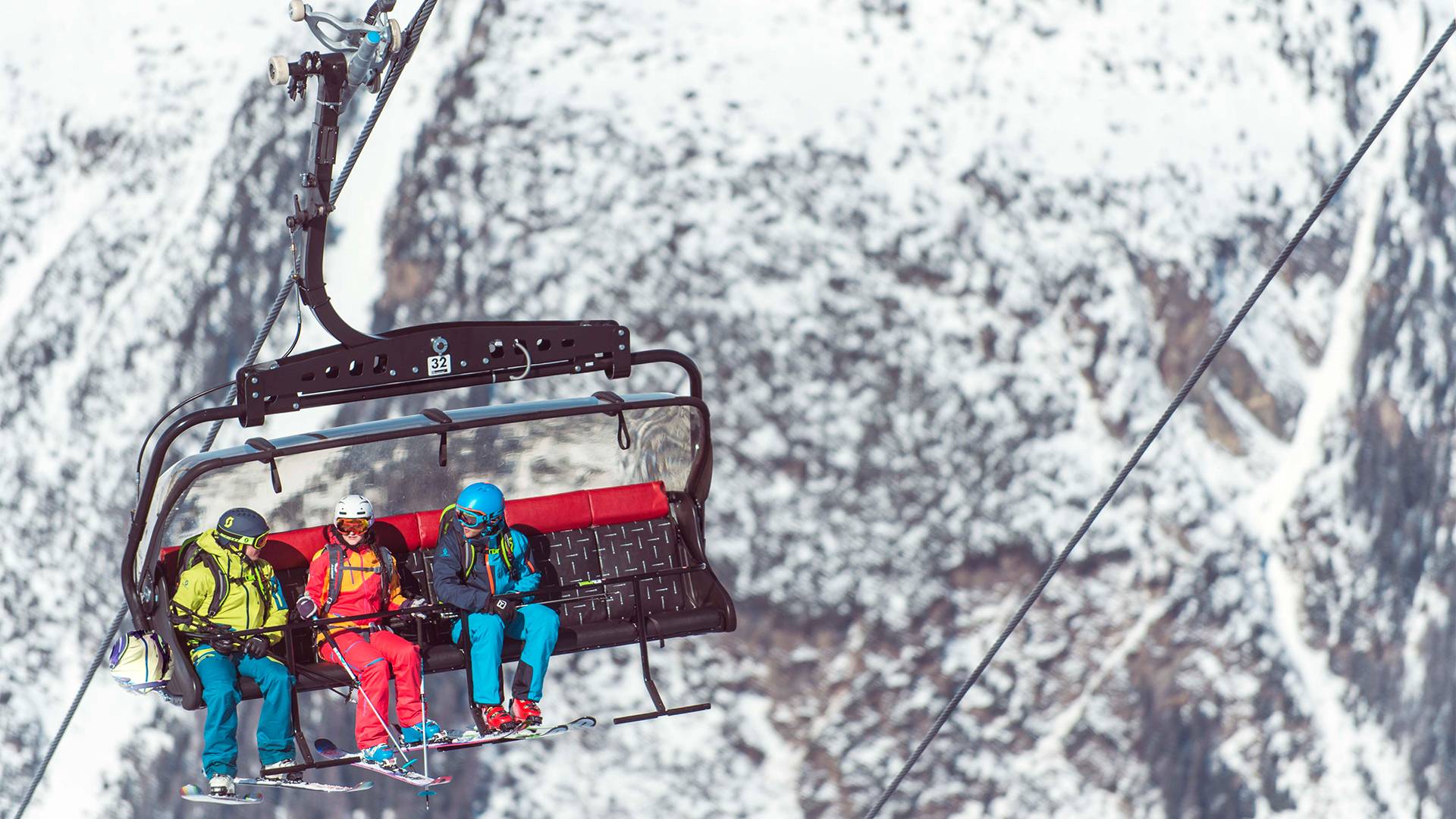 Several people sit in the lift on their way to the summit.