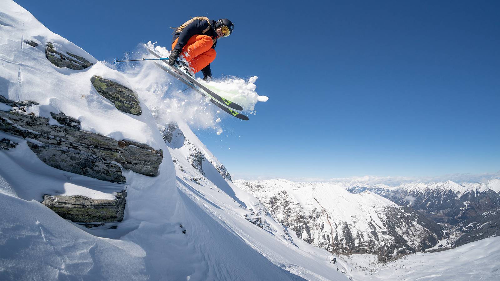 Eine Freestyle-Skifahrerin springt über steiles Gelände.