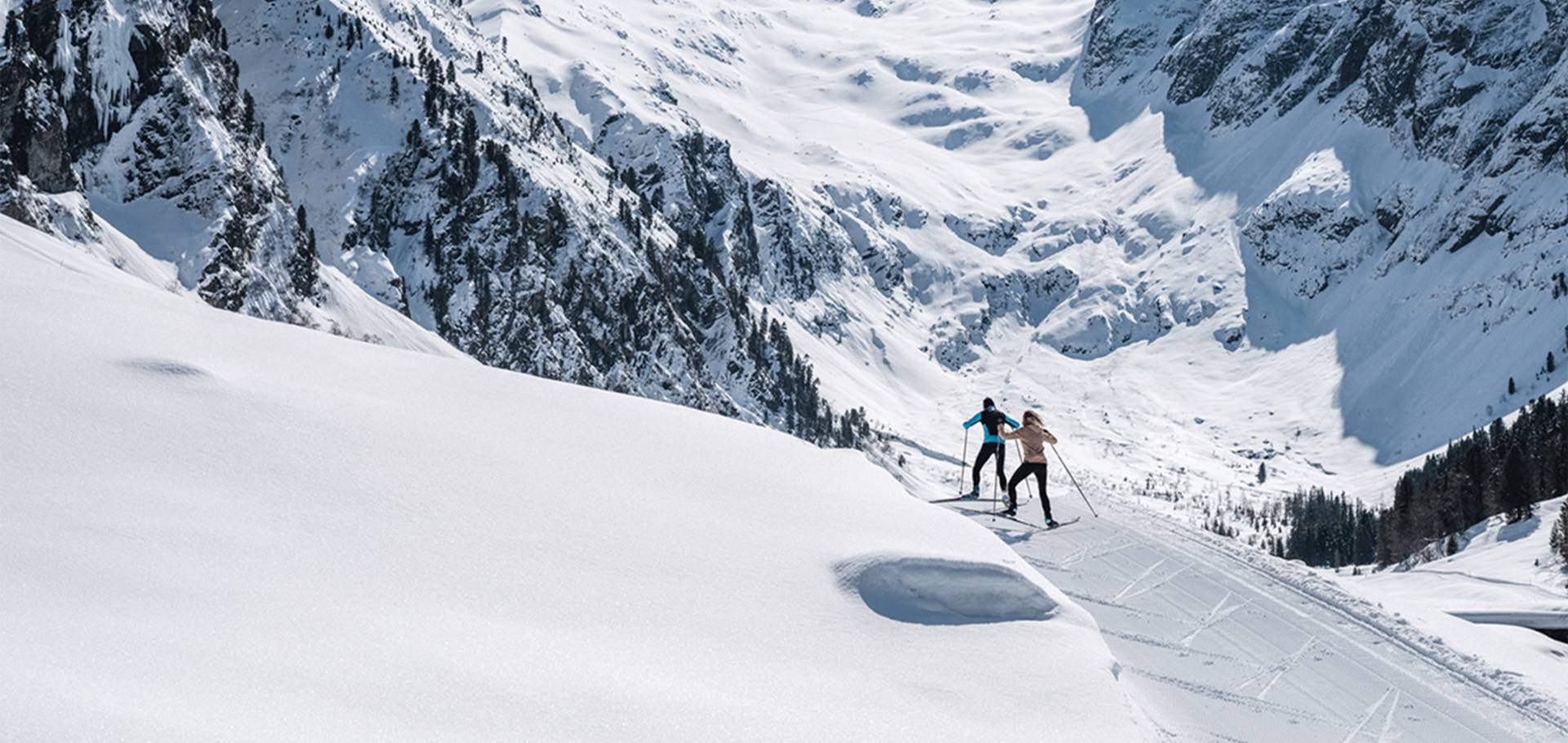 A shot of two cross-country skiers on a cross-country ski trail in a beautiful winter landscape.