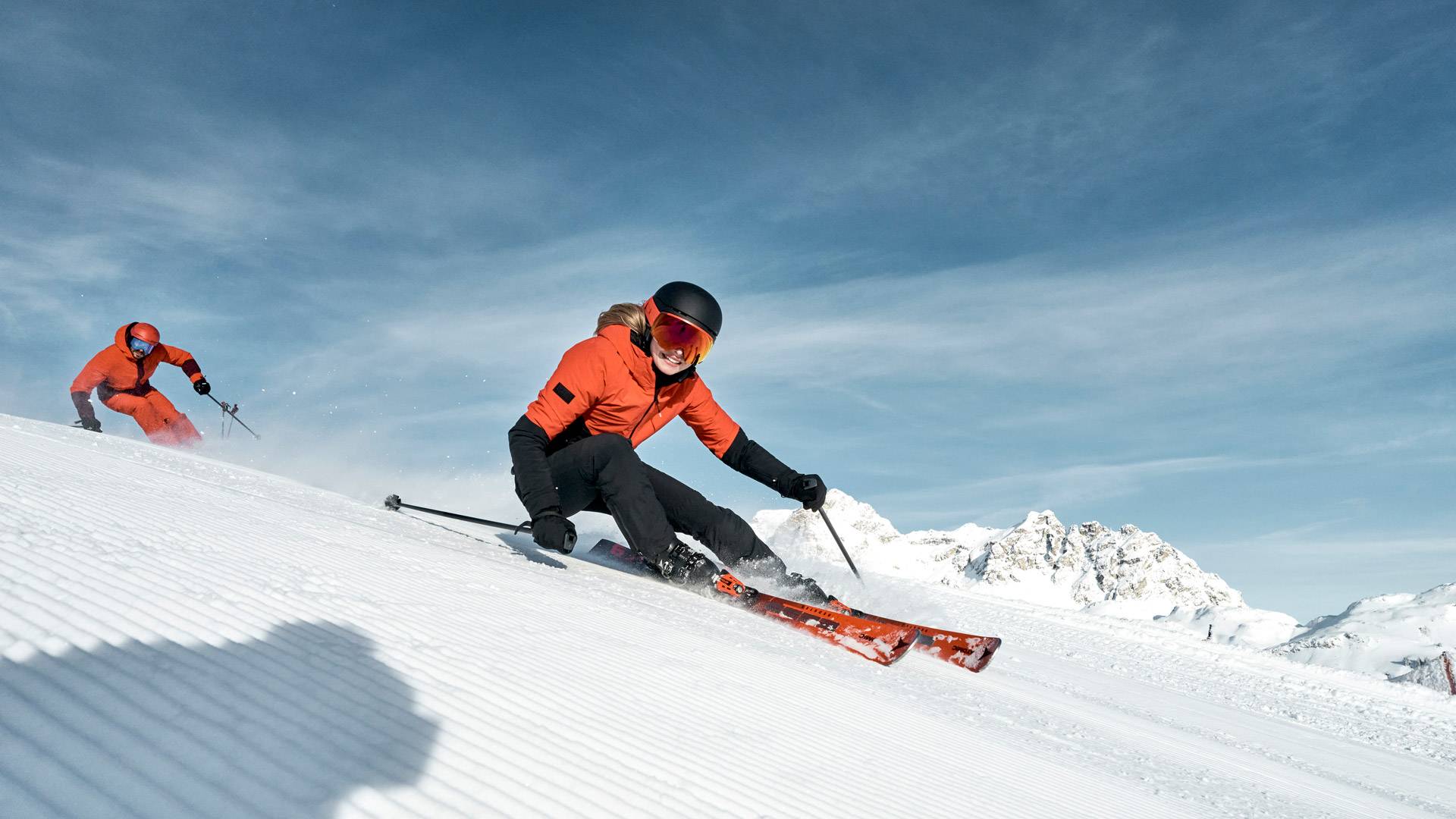 zwei Skifahrer beim Skifahren auf einer frisch präparierten Skipiste