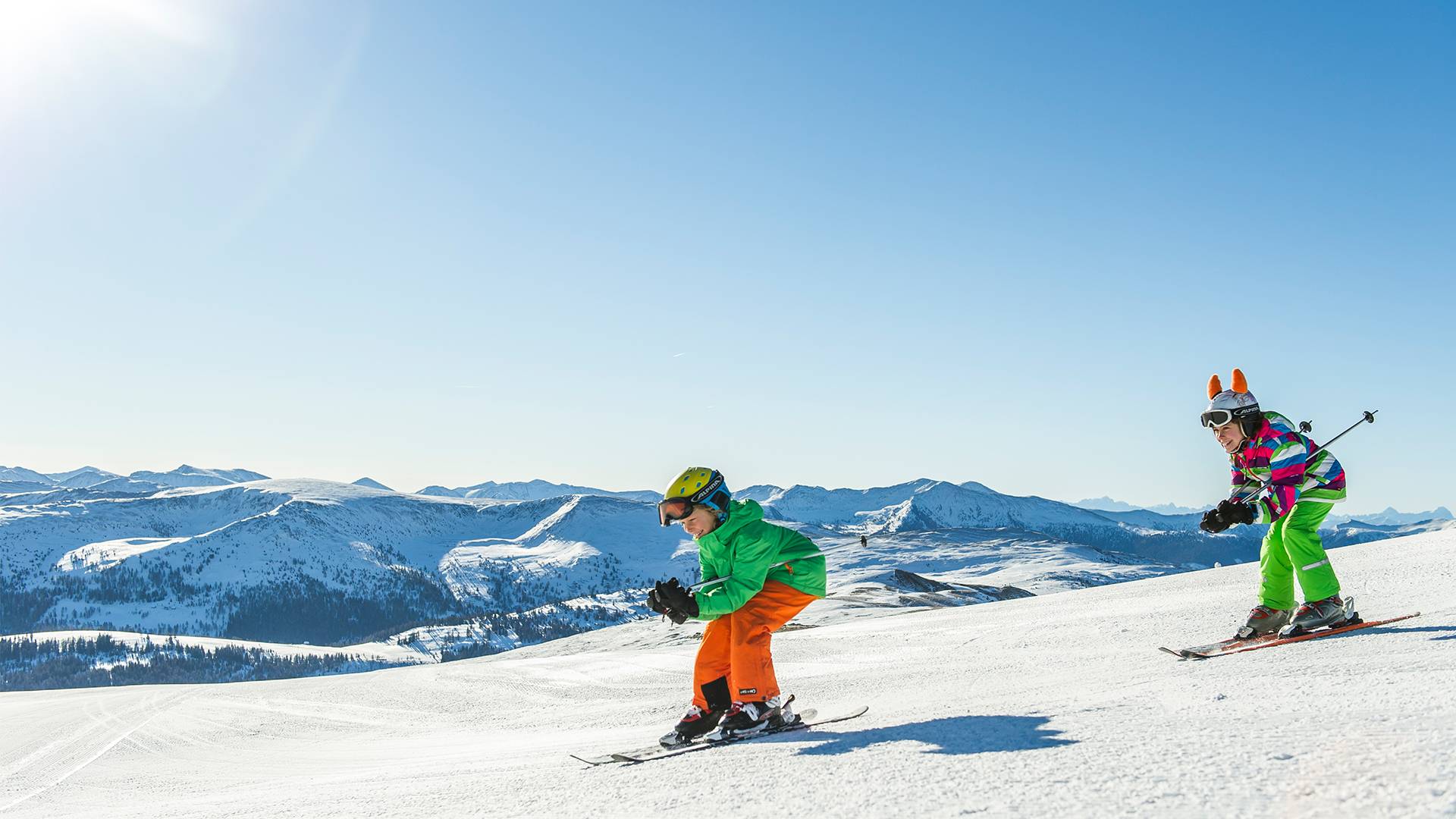 Kinderen genieten van de afdaling op de piste.