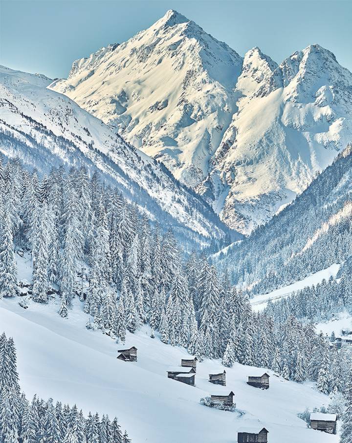 Zu sehen ist eine traumhaft schöne Winterlandschaft. Im Hintergrund thront eine schneebedeckter Berg.