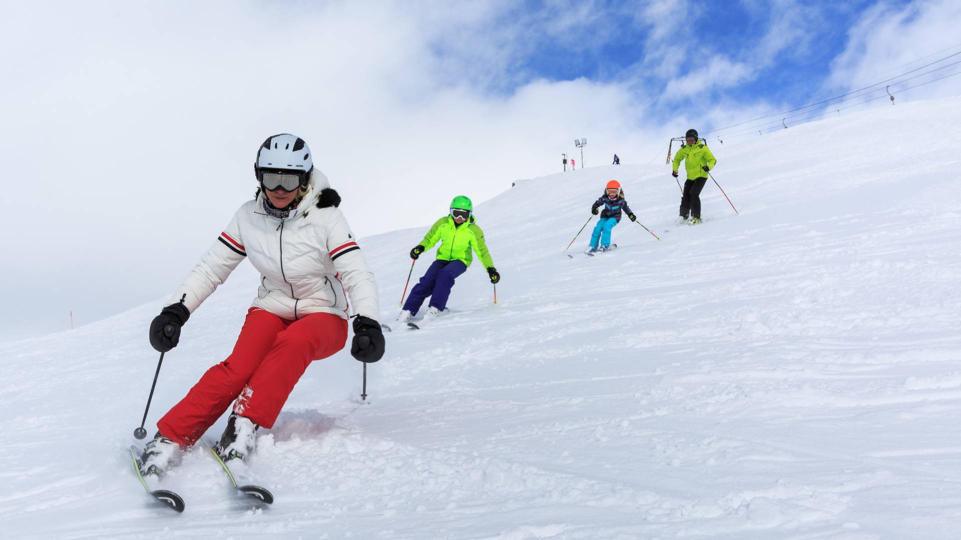 Several people skiing down the slope in Uttendorf one behind the other.