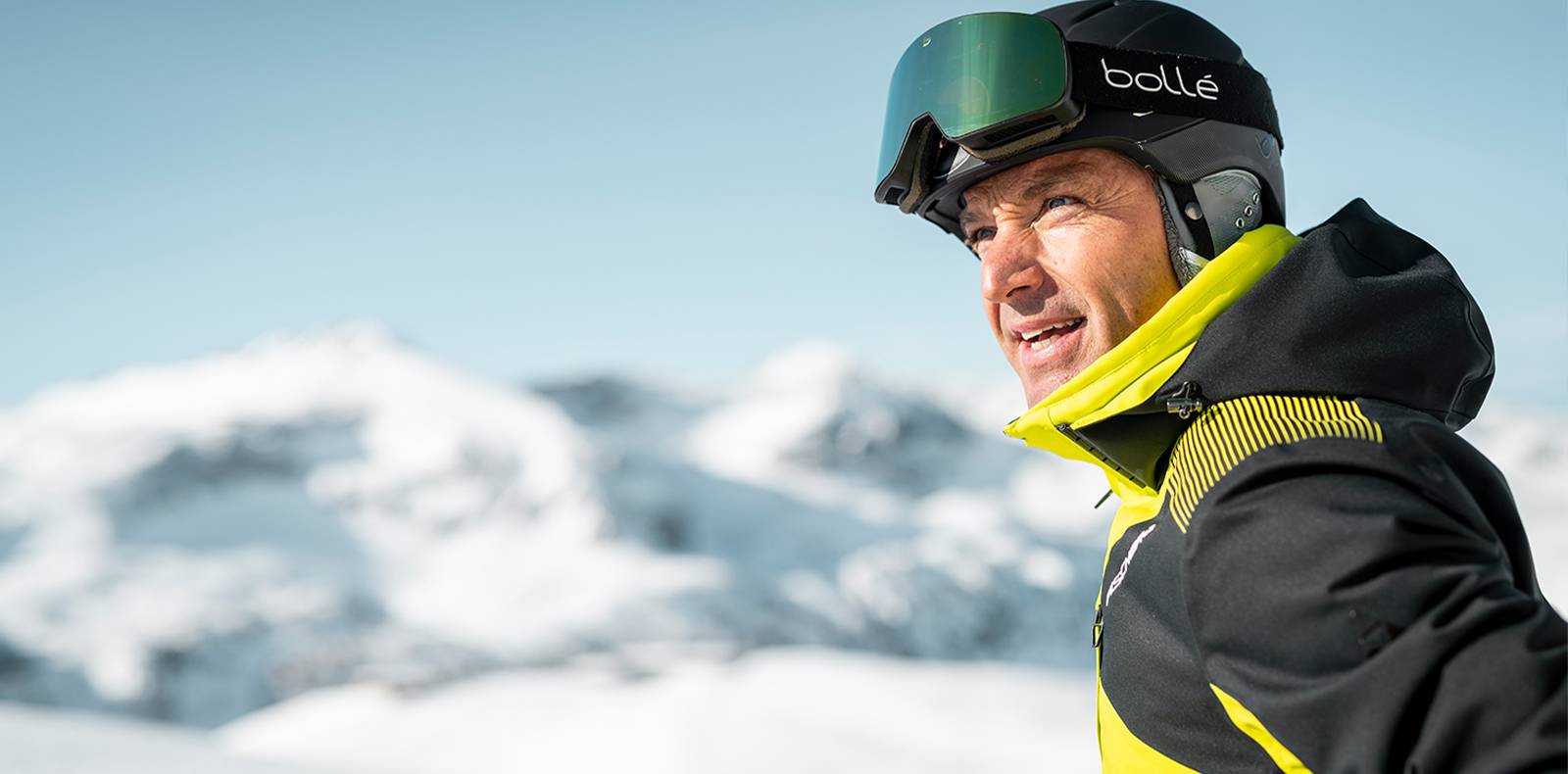 Auf dem Bild sieht man einen Skifahrer welcher in die Ferne blickt.