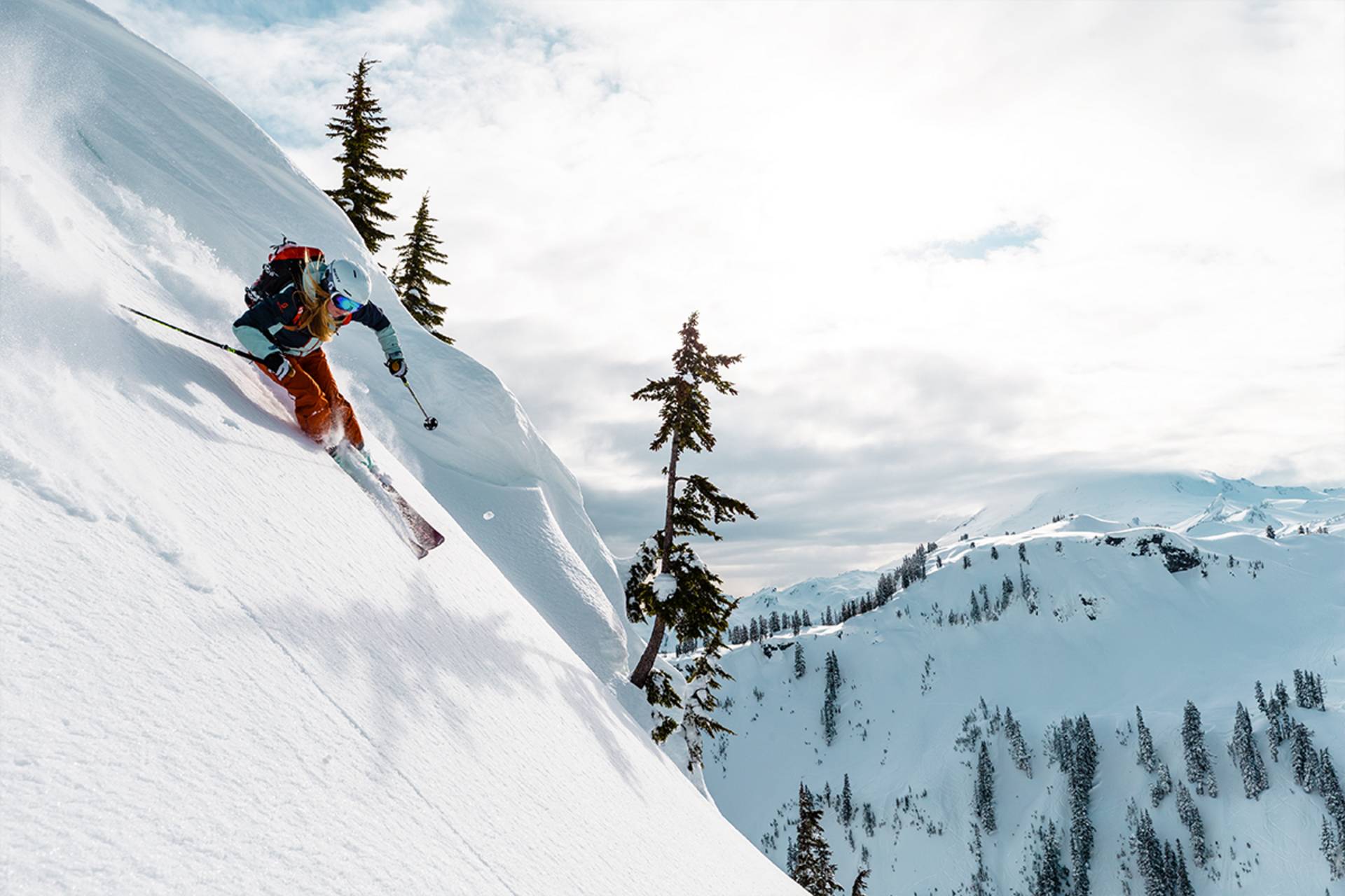 Hier skiet een skiër een steile piste af.
