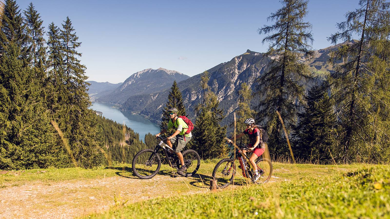 Zwei Mountainbiker bei der Radfahrt am Zwölferkopf mit dem Achensee im Hintergrund.