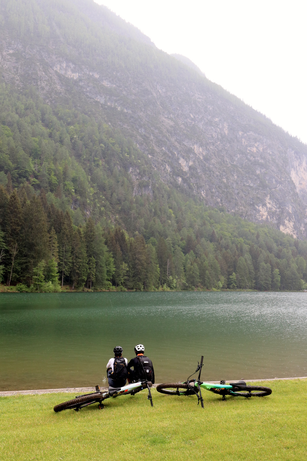 Ein Biker genießt die Rast beim Ufer eines Bergsees.
