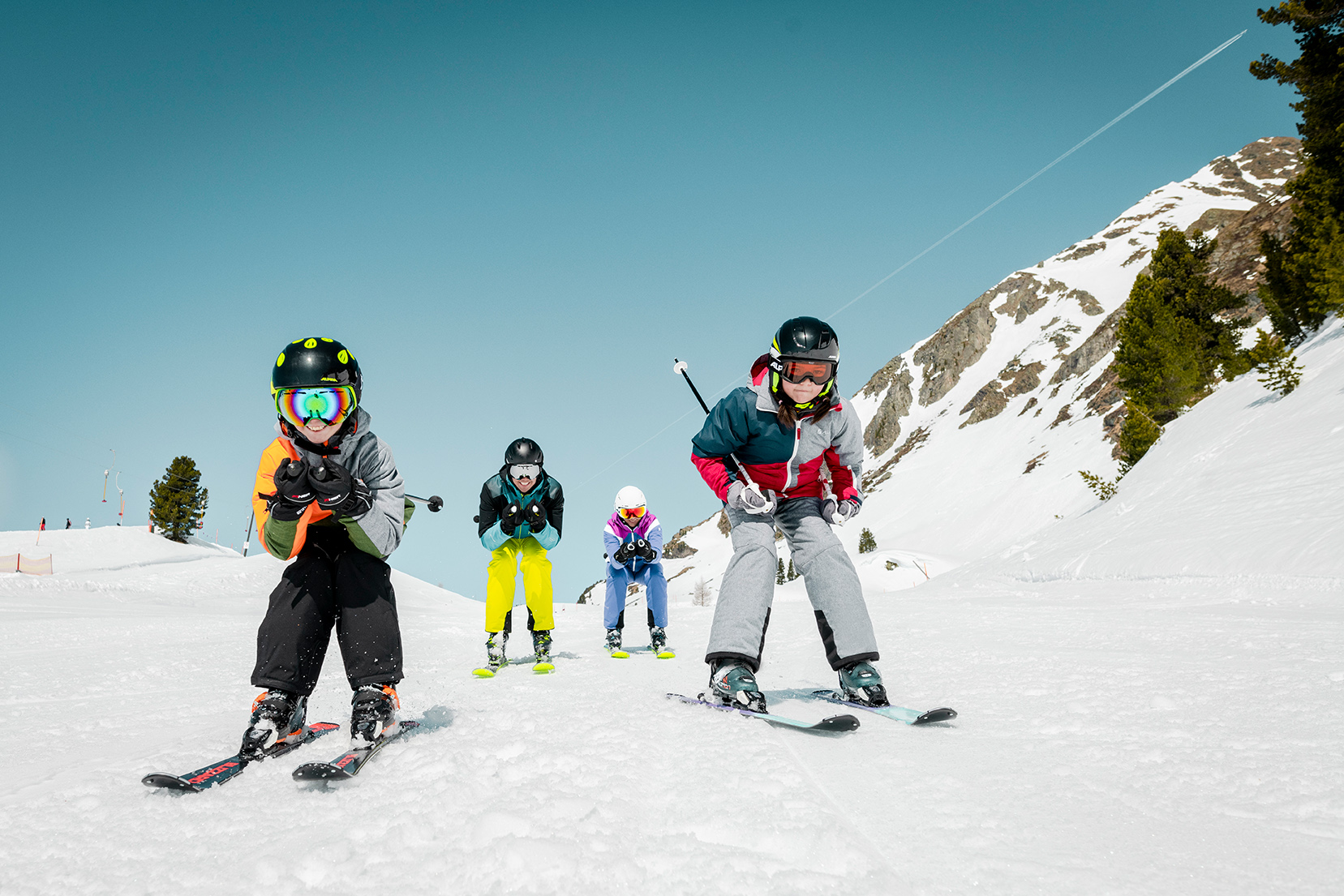 Familie in Abfahrtshocke auf der Piste.