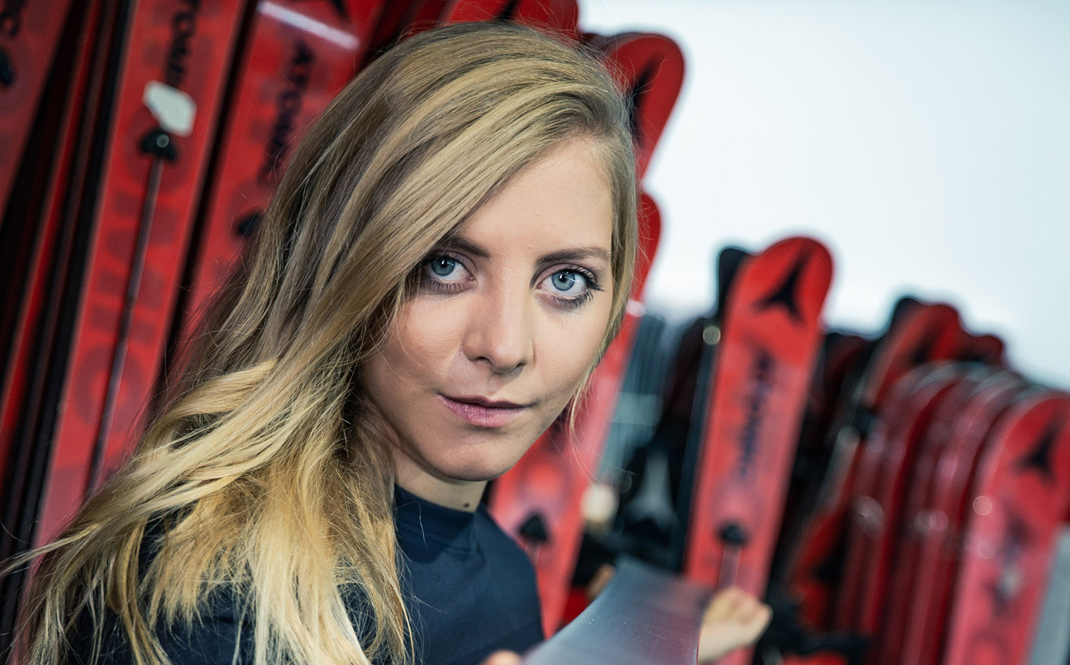 Ein Foto von Katharina Gallhuber, wo sie einen Atomic Ski in die Kamera hält.