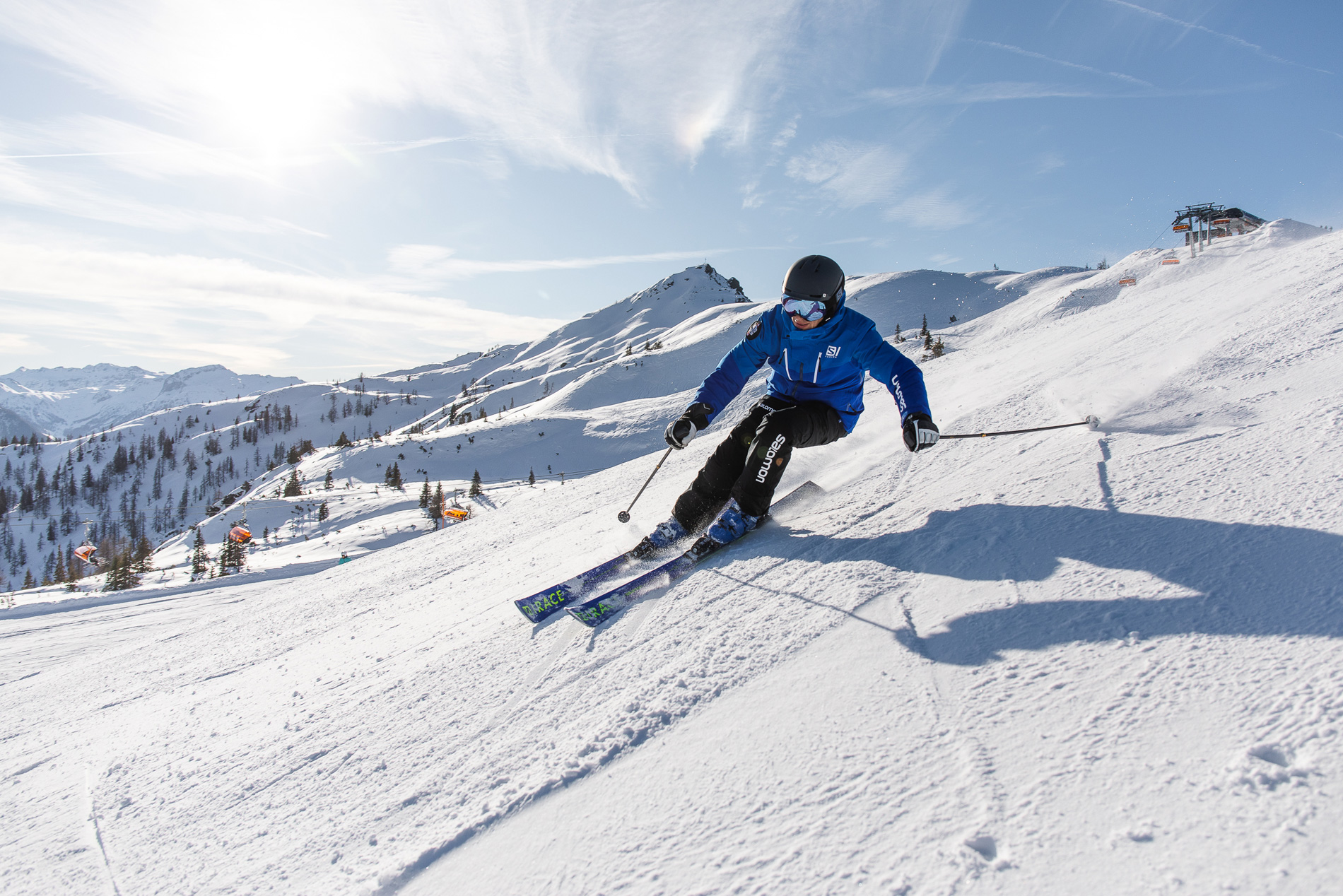 Er fährt die Skipiste herab.