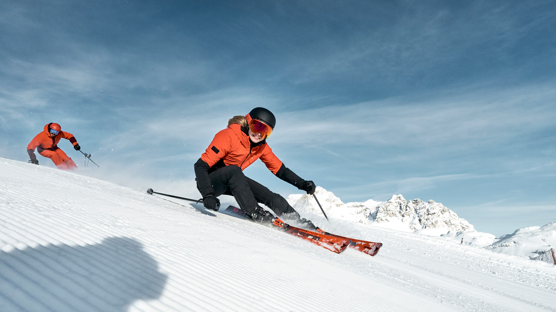 twee skiërs die skiën op een vers geprepareerde skipiste