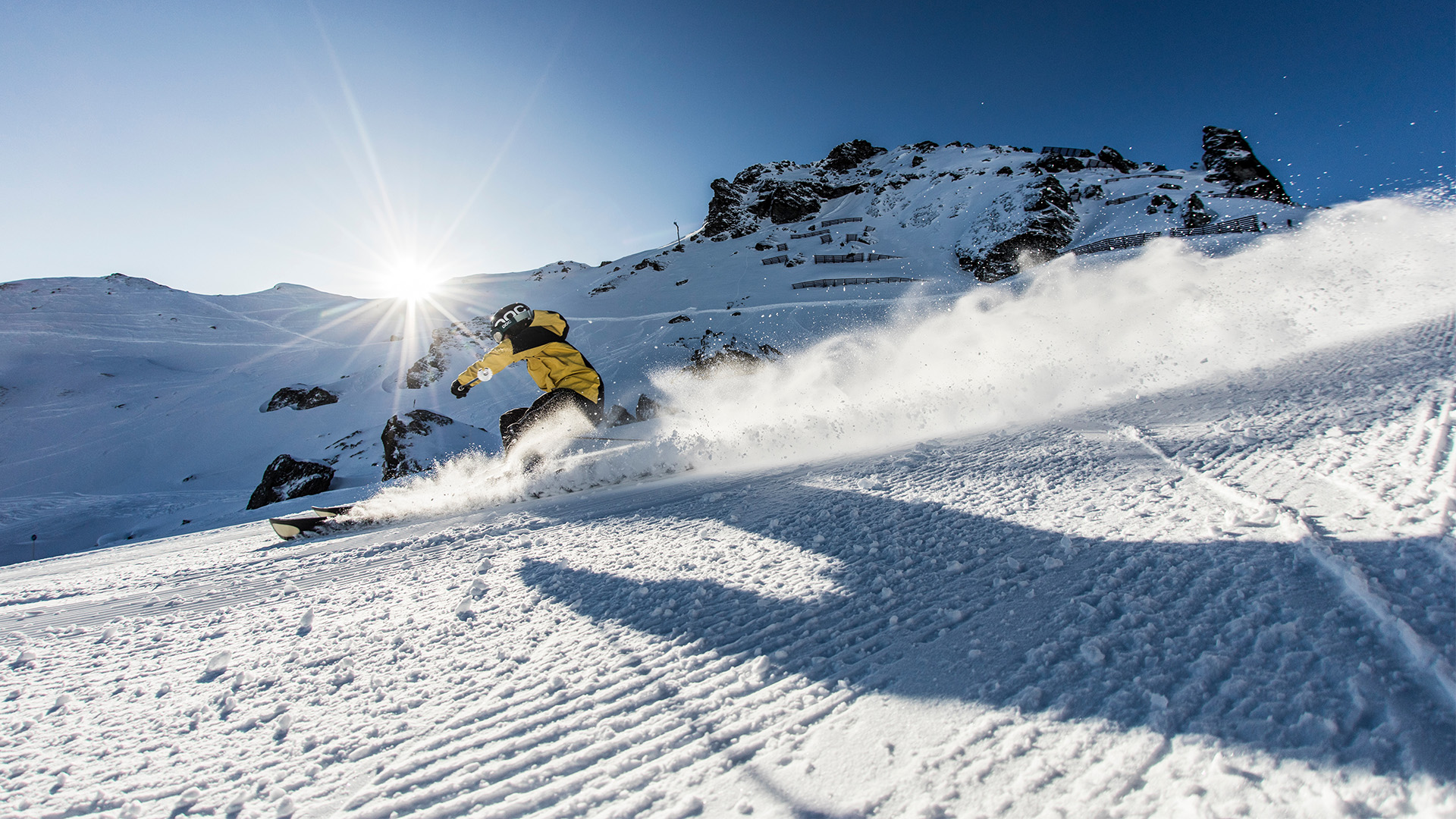 Zwei Skifahrer gehen mit ihrer Ausrüstung über die Piste.