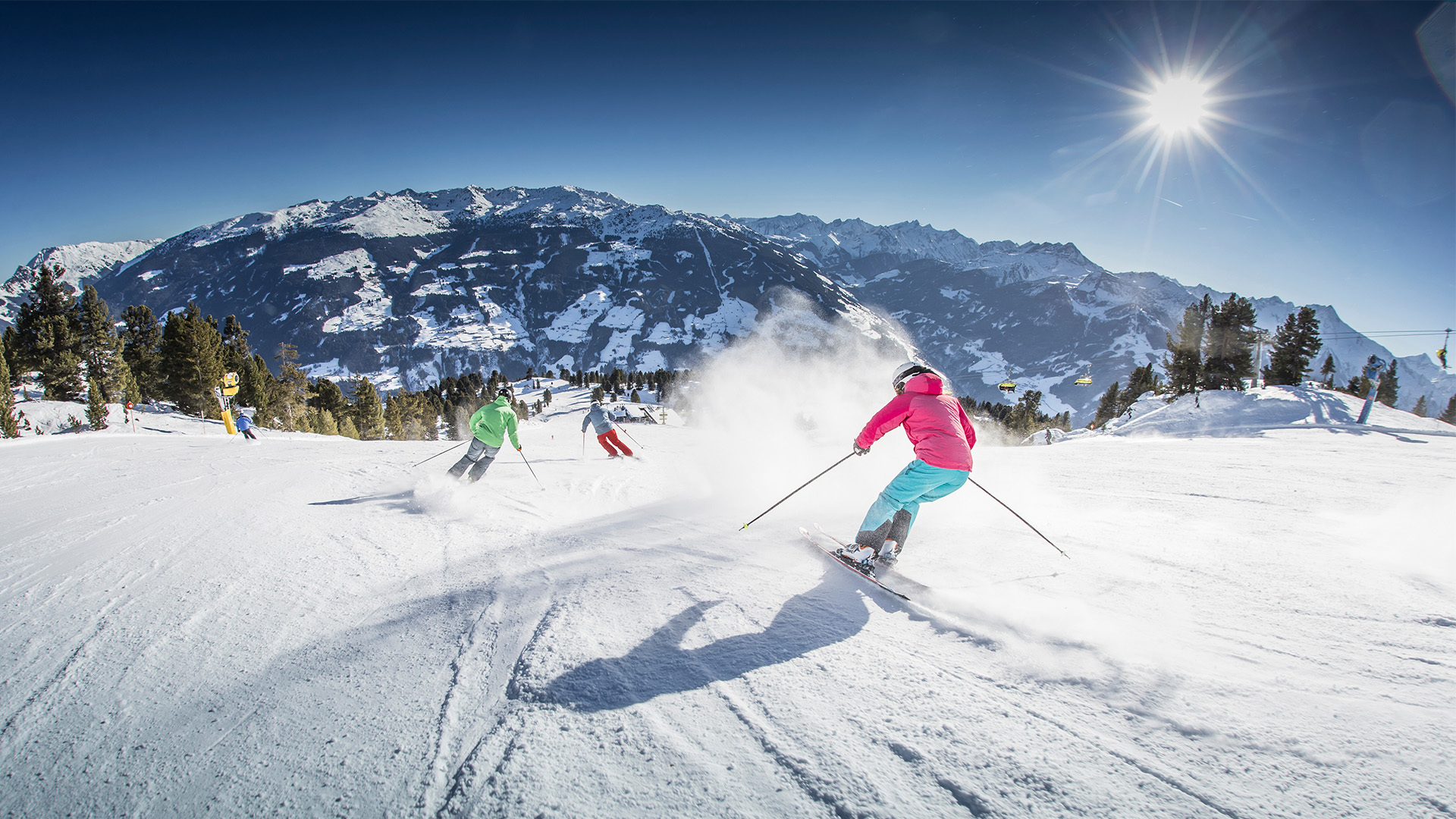 Drei Personen fahren auf einer Skipiste in Kaltenbach.