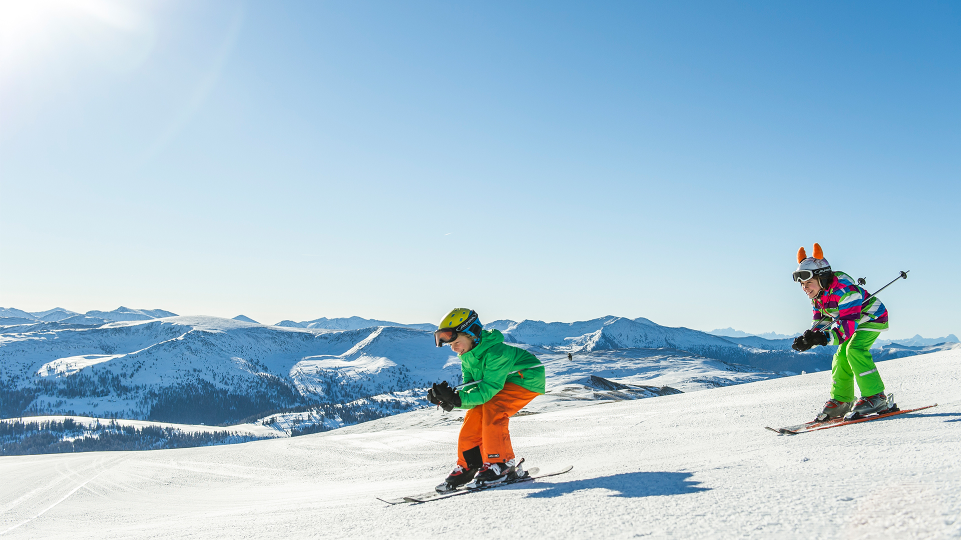 Kinder genießen die Abfahrt auf der Piste.